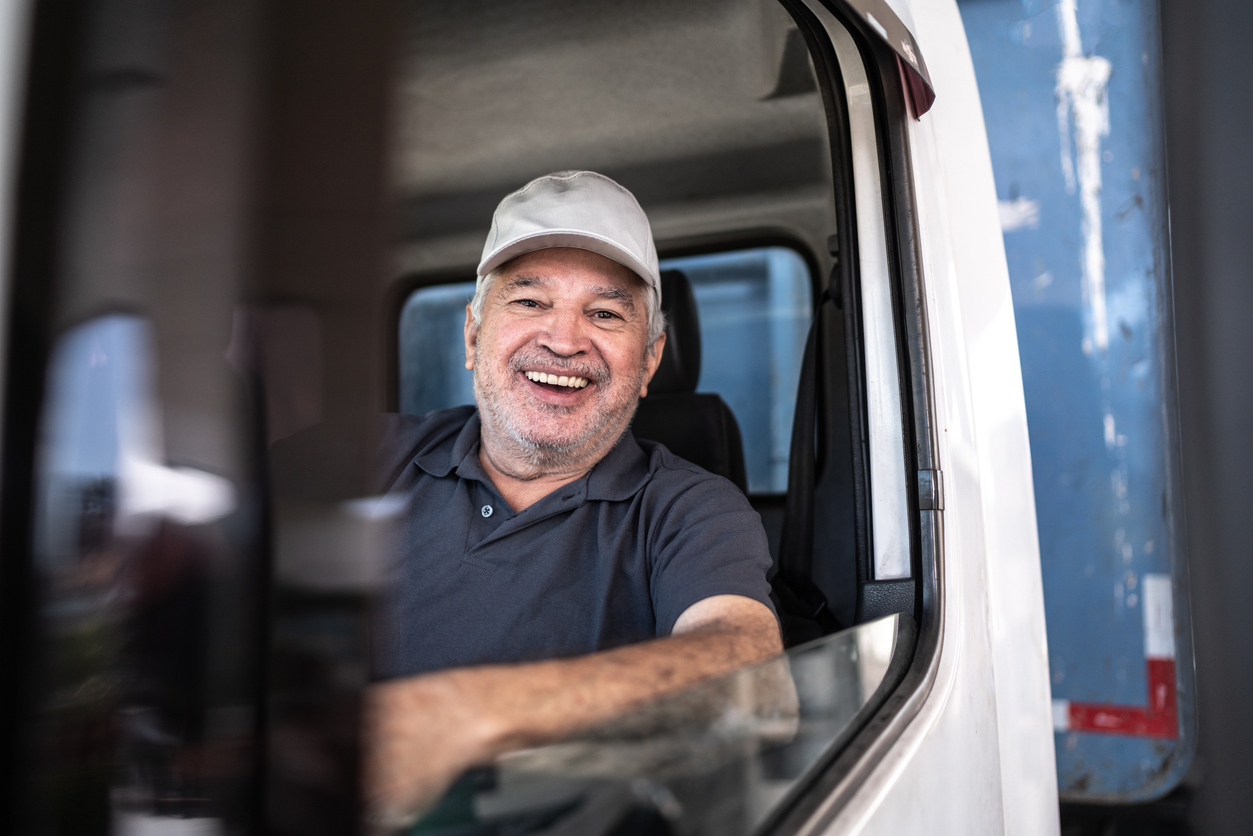 Portrait of a senior male truck driver sitting in cab