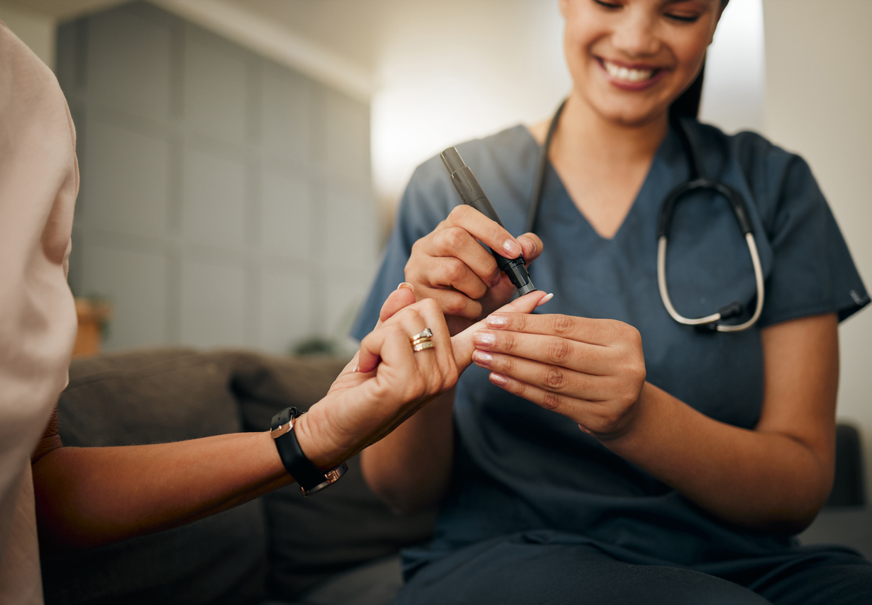 Zoom of doctor, diabetes or elderly woman hands with blood test, sugar or medical test with a glucometer. Healthcare, health nurse or diabetic lady consulting on glucose wellness in living room